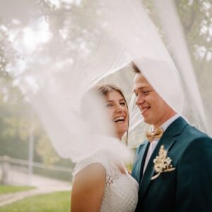 Bride,And,Groom,Share,A,Joyful,Laugh,Under,A,Flowing Enjoying their Wedding Day